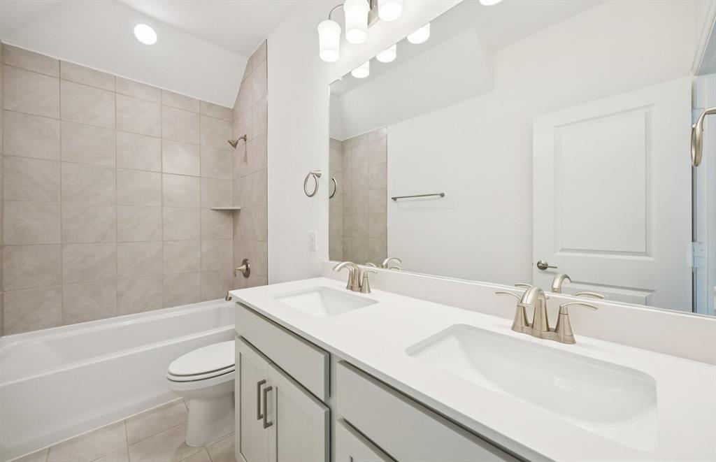 3048 Cliffside Drive Celina, TX 75009 - Photo 14 of 14 a bathroom with a sink a toilet and a large mirror