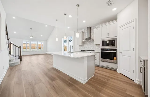a large kitchen with stainless steel appliances kitchen island a large counter top and a sink