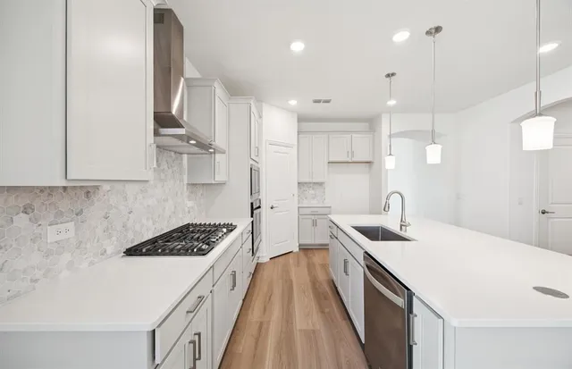 a kitchen with counter top space a sink stainless steel appliances and cabinets