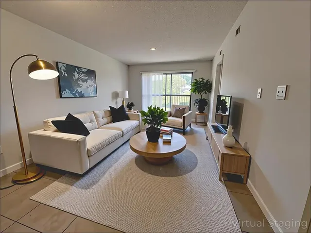 a living room with furniture a large window and a flat screen tv