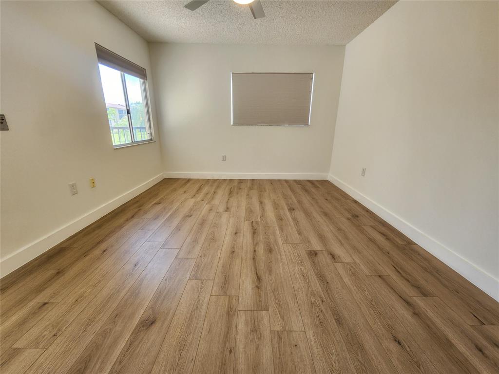 1650 Southwest 124th Terrace, Unit 209D Pembroke Pines, FL 33027 - Photo 17 of 19 an empty room with wooden floor and windows