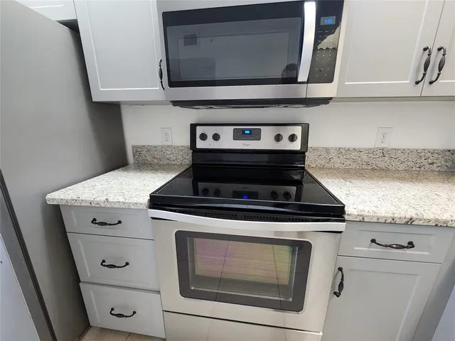 a stove top oven sitting inside of a kitchen