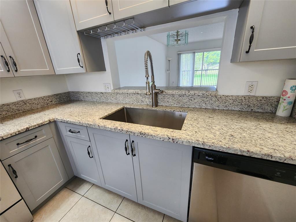 1650 Southwest 124th Terrace, Unit 209D Pembroke Pines, FL 33027 - Photo 6 of 19 a kitchen with granite countertop a sink and a stove