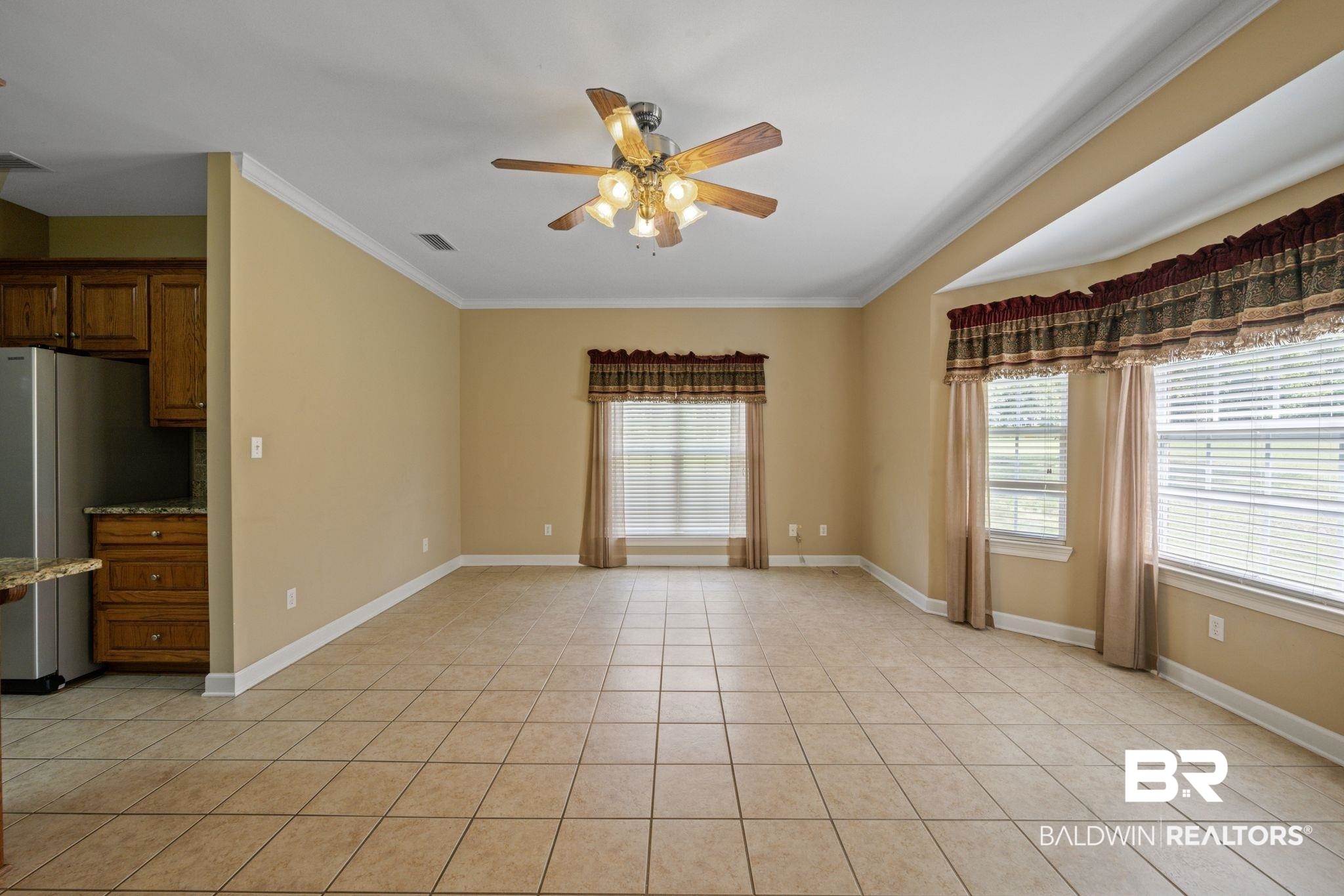 5618 Leytham Road Theodore, AL 36582 - Photo 25 of 60 Empty room featuring ceiling fan, a wealth of natural light, and light tile patterned floors