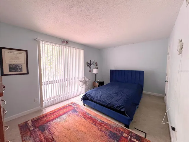 a bedroom with a large bed and wooden floor