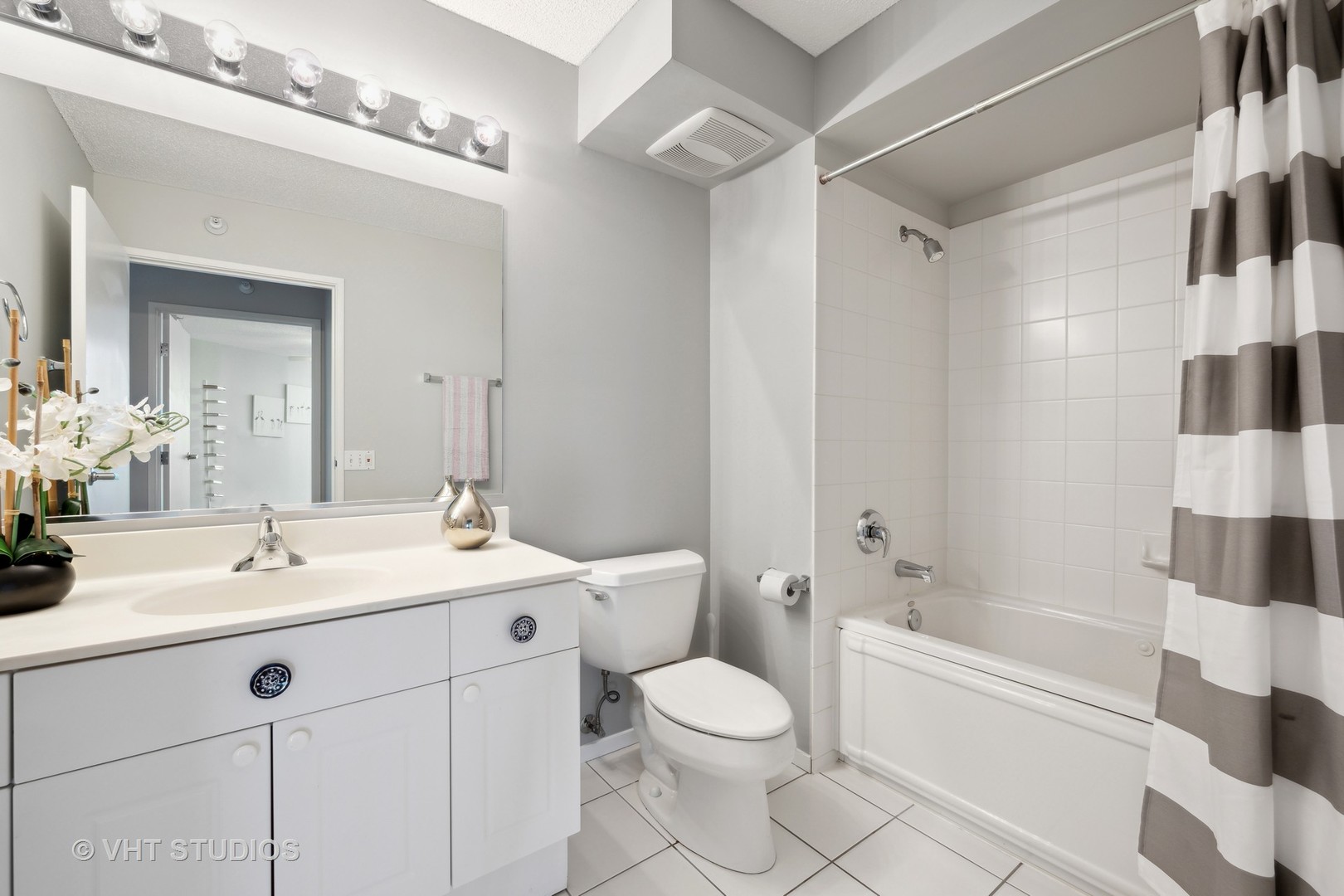1720 Maple Avenue, Unit 1040 Evanston, IL 60201 - Photo 17 of 35 a bathroom with a toilet a sink a mirror a bathtub and shower