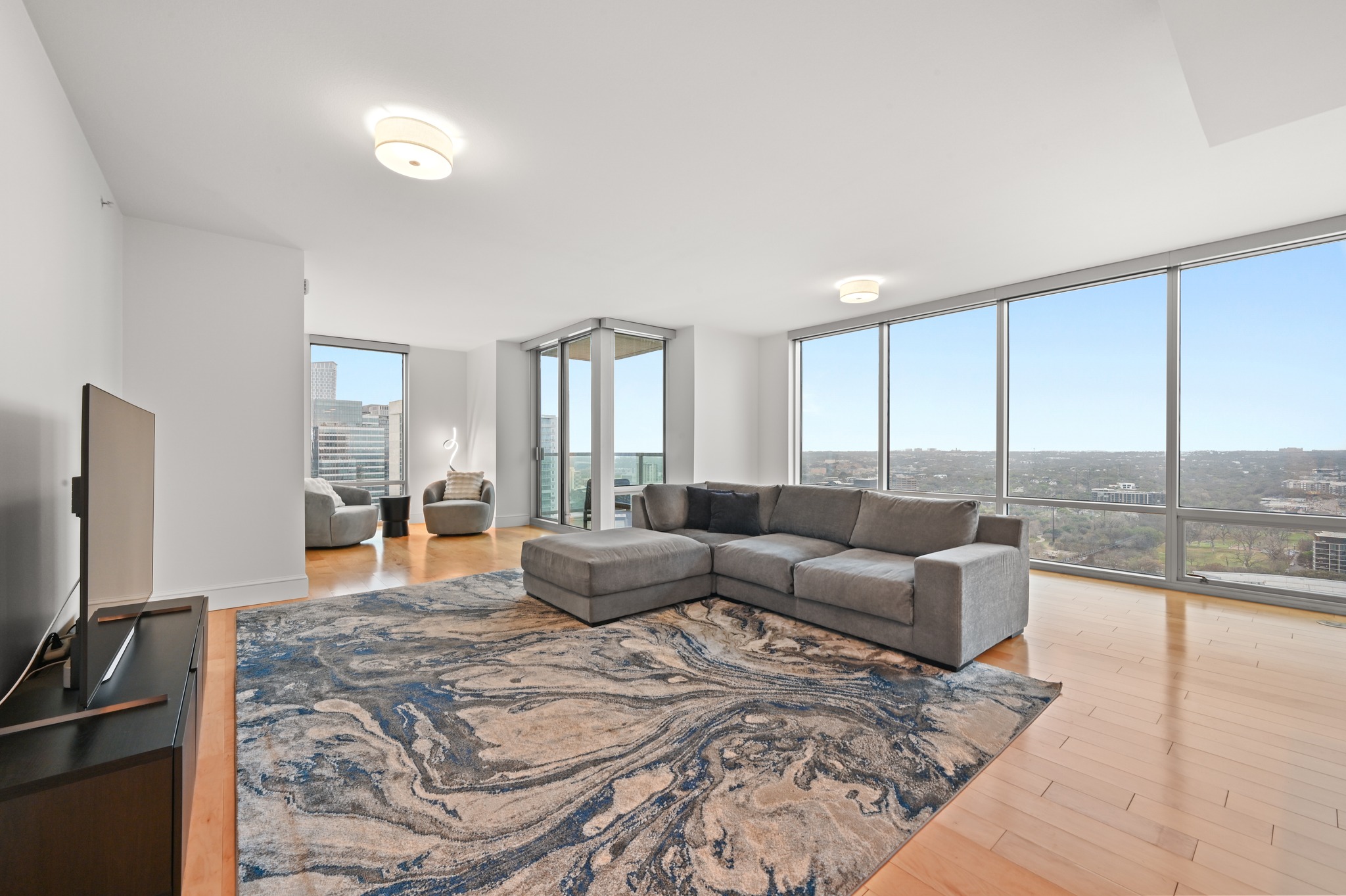 300 Bowie Street, Unit 2902 Austin, TX 78703 - Photo 2 of 40 a living room with furniture and a flat screen tv