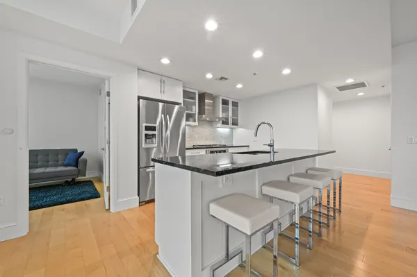 a kitchen with stainless steel appliances granite countertop a sink and a refrigerator