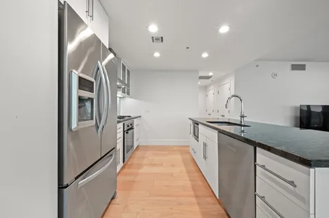a kitchen with stainless steel appliances granite countertop a refrigerator and a sink