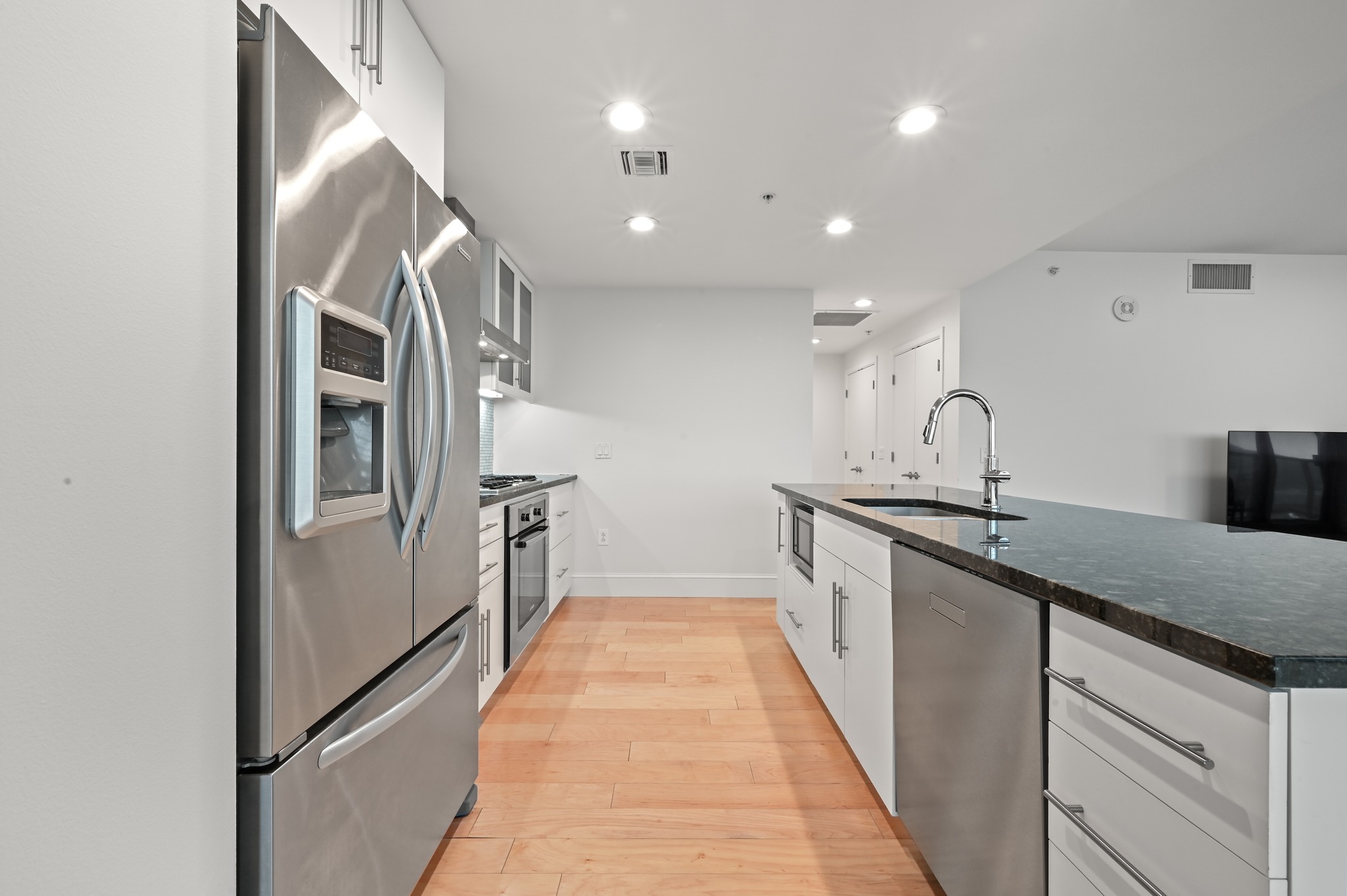 300 Bowie Street, Unit 2902 Austin, TX 78703 - Photo 9 of 40 a kitchen with stainless steel appliances granite countertop a refrigerator and a sink