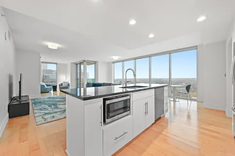 a kitchen with stainless steel appliances granite countertop a stove and white cabinets