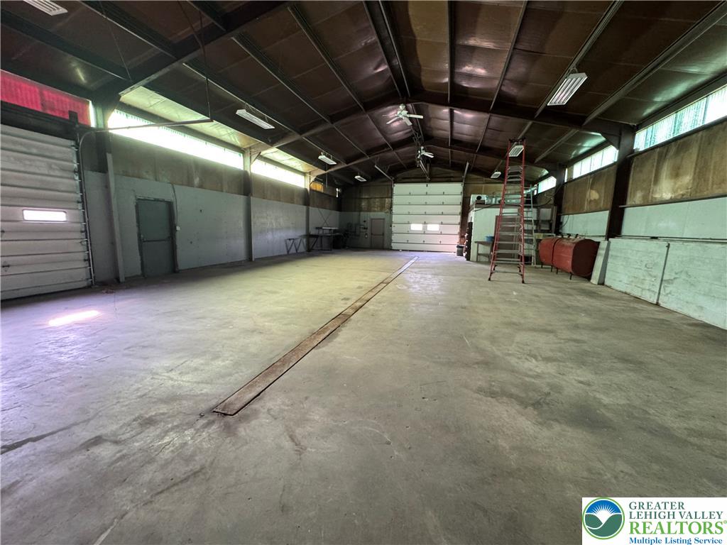 868 Catawissa Road Tamaqua, PA 18252 - Photo 65 of 67 Large warehouse space featuring robust concrete flooring and multiple roll-up doors, ideal for industrial operations.