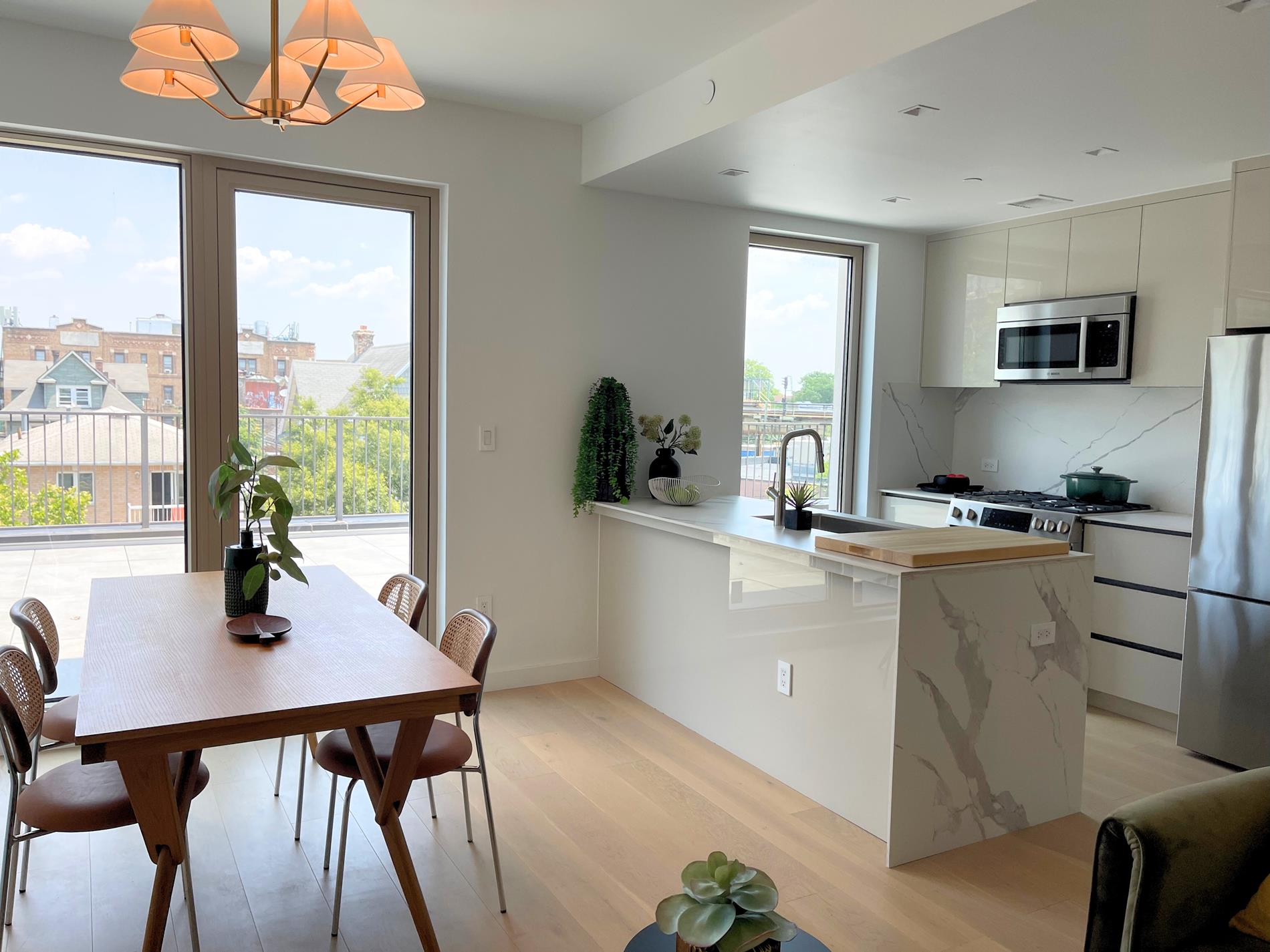 1548 72nd Street, Unit 302 Brooklyn, NY 11228 - Photo 6 of 12 a kitchen with a table chairs white cabinets and wooden floor