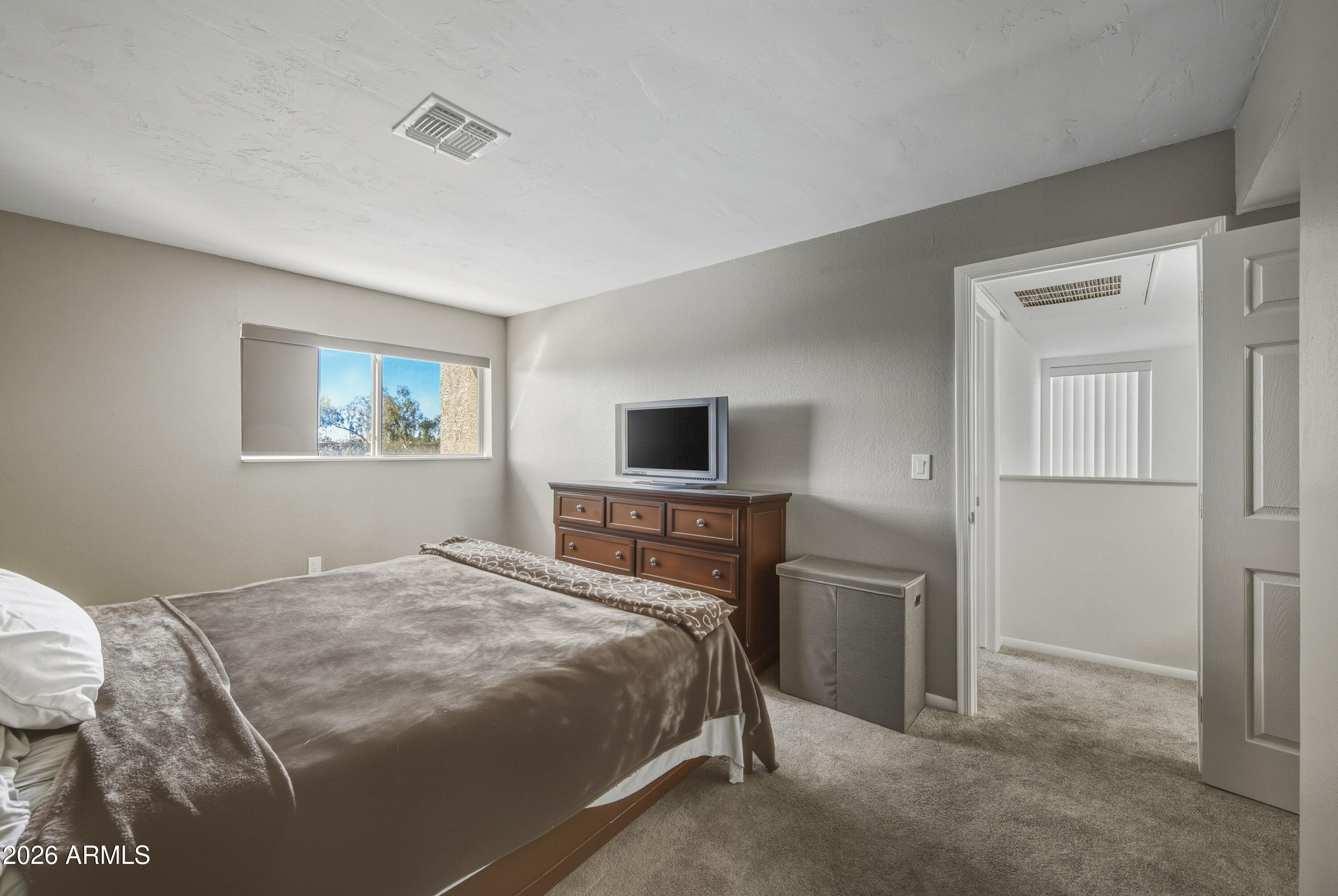 1645 West Baseline Road, Unit 2002 Mesa, AZ 85202 - Photo 10 of 21 a bedroom with a bed and a tv
