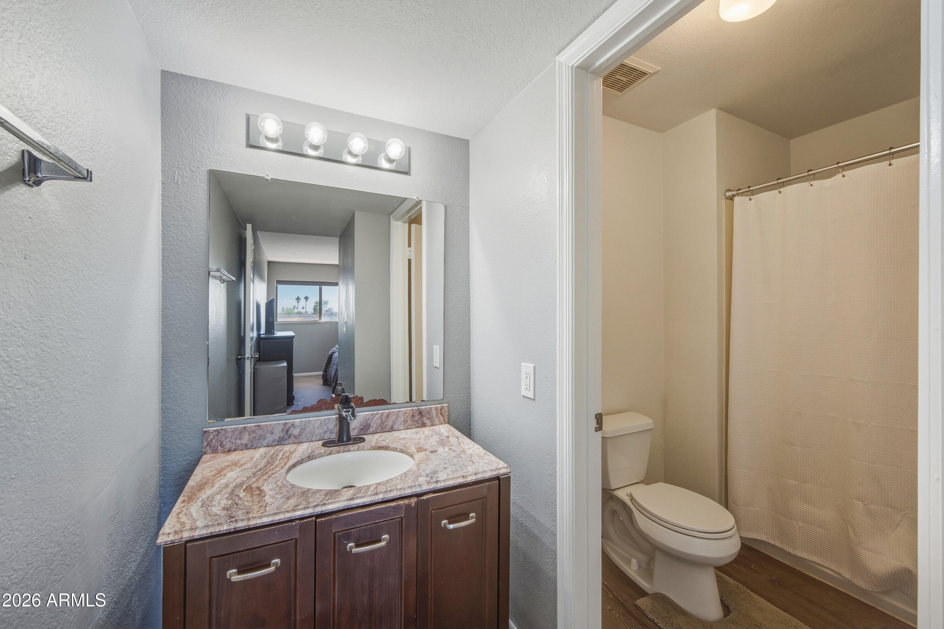 1645 West Baseline Road, Unit 2002 Mesa, AZ 85202 - Photo 13 of 21 a bathroom with a granite countertop sink a toilet and a mirror