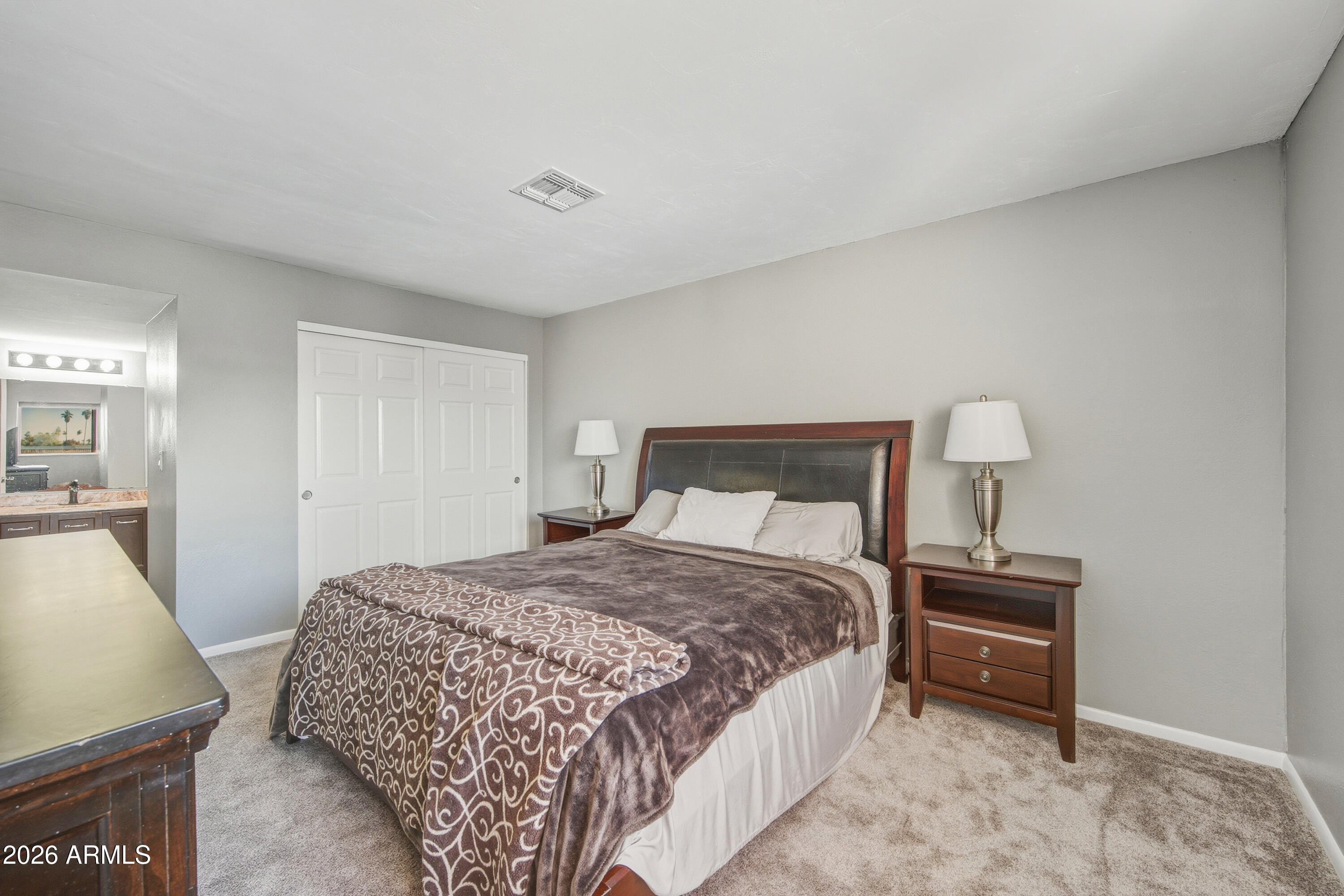 1645 West Baseline Road, Unit 2002 Mesa, AZ 85202 - Photo 9 of 21 a bedroom with a bed and a lamp on table