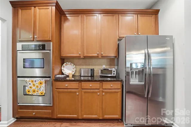 a kitchen with granite countertop a stove a microwave a sink and cabinets
