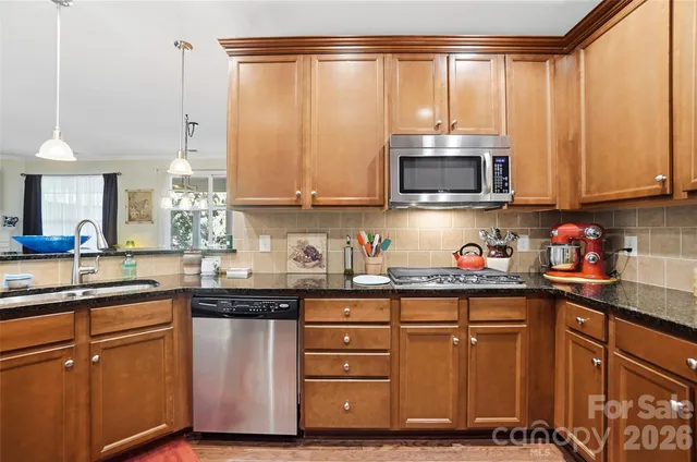 a kitchen with stainless steel appliances granite countertop a refrigerator and a stove top oven