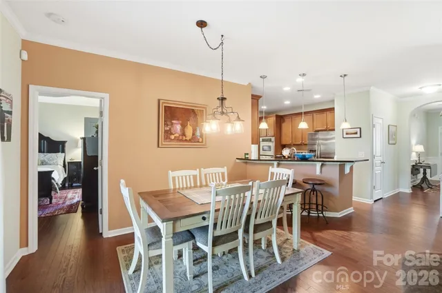 a dining room with furniture a chandelier and wooden floor