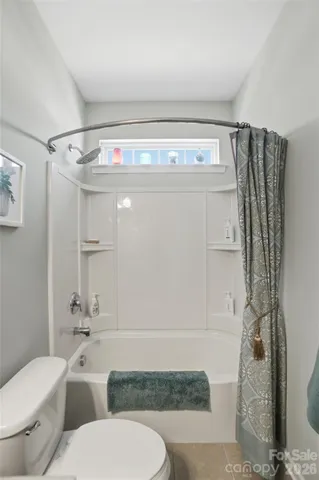 a bedroom with a bed couch and a window