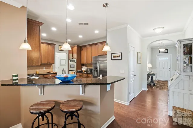 a kitchen with kitchen island granite countertop a sink stainless steel appliances and cabinets