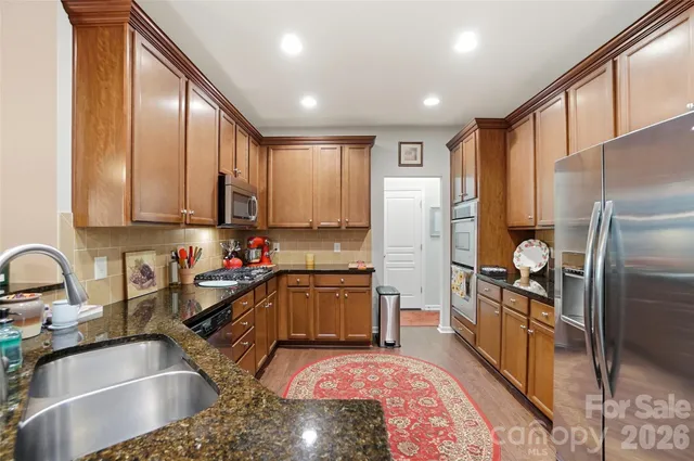 a kitchen with stainless steel appliances granite countertop a sink stove microwave and cabinets