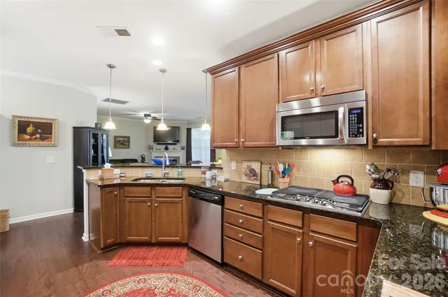a kitchen with stainless steel appliances granite countertop a refrigerator and a stove