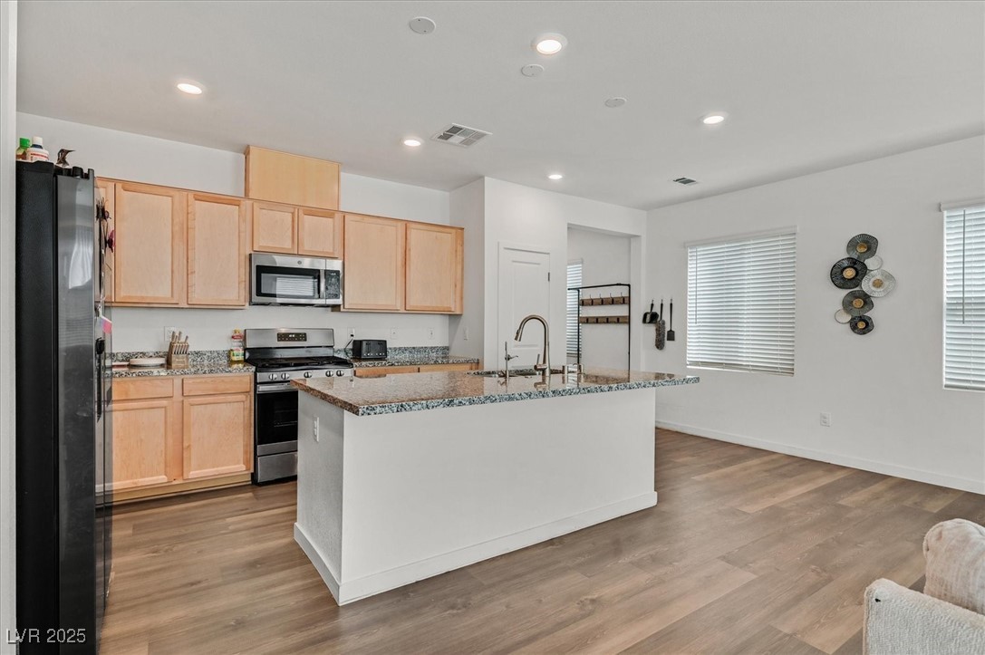 2885 Timber Country Road North Las Vegas, NV 89086 - Photo 9 of 26 Kitchen featuring appliances with stainless steel finishes, visible vents, light brown cabinetry, and a sink