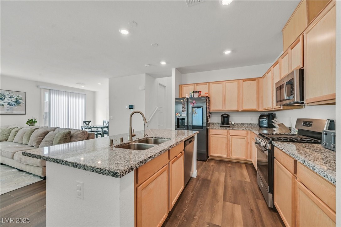 2885 Timber Country Road North Las Vegas, NV 89086 - Photo 10 of 26 Kitchen featuring light brown cabinetry, dark wood-style flooring, stainless steel appliances, and a sink