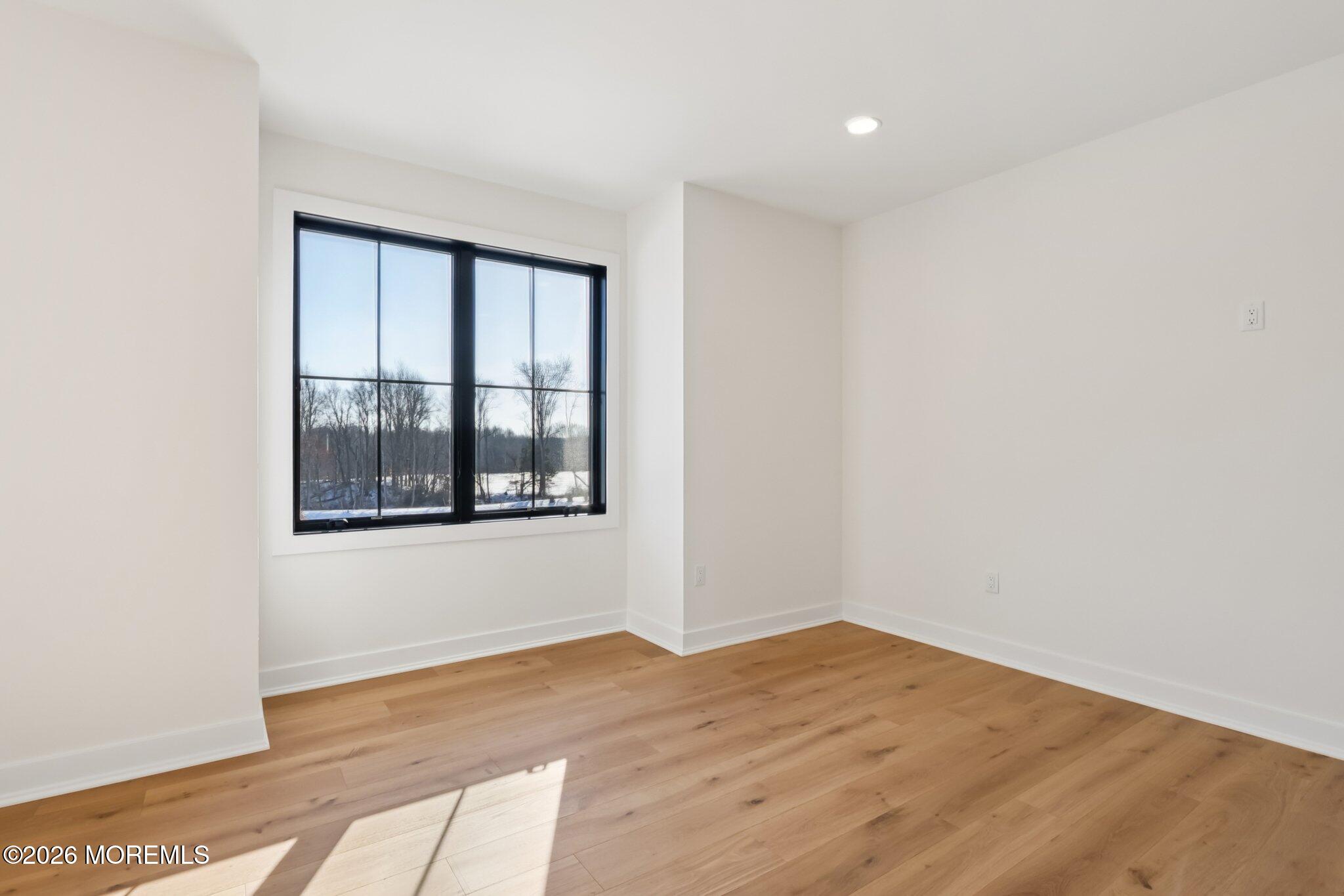 4 Fortune Court Freehold, NJ 07728 - Photo 5 of 104 a view of an empty room with wooden floor and a window