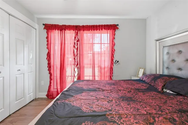 a bedroom with a large bed and a wooden floor
