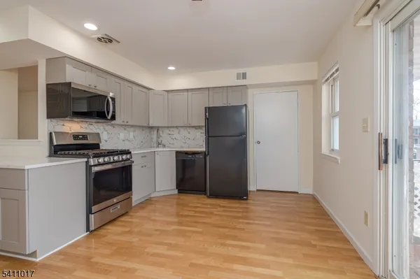 a kitchen with refrigerator a microwave and cabinets