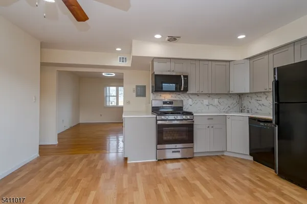 a kitchen with granite countertop a refrigerator and a stove top oven