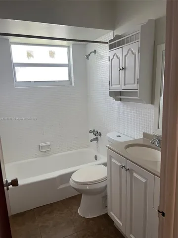 a bathroom with a granite countertop toilet a sink and a bathtub
