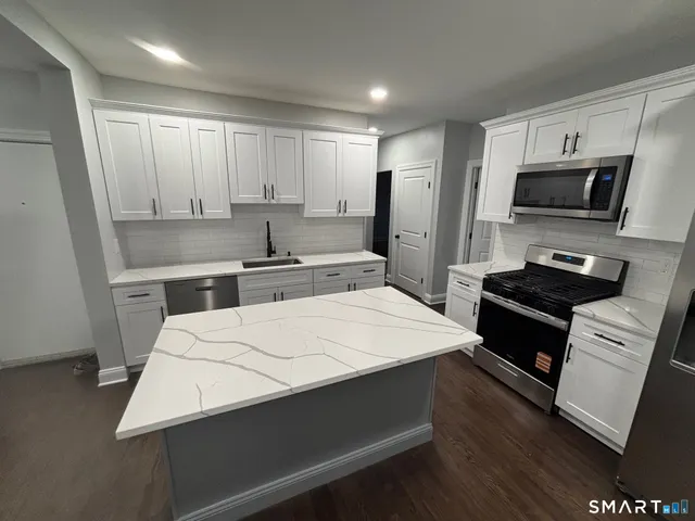 a kitchen with stainless steel appliances a refrigerator sink and microwave