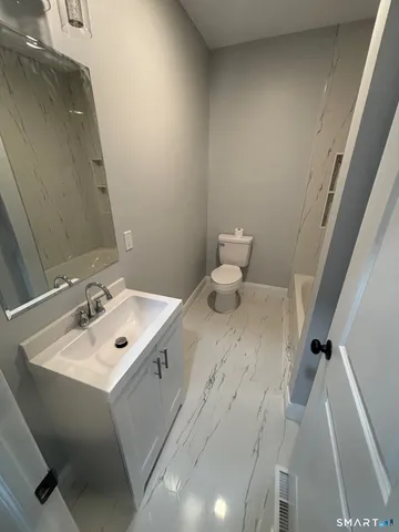 a bathroom with a sink mirror and toilet
