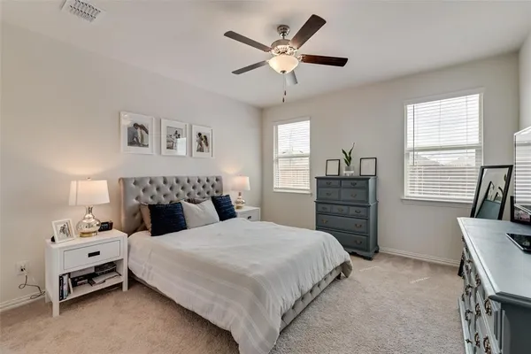 a bedroom with a bed a dresser and a window