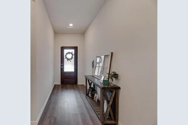 a view of a hallway with wooden floor and a workspace