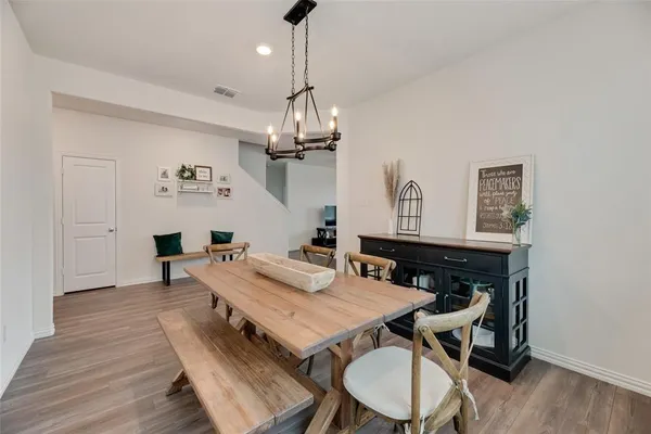 a view of a dining room with furniture a chandelier and wooden floor