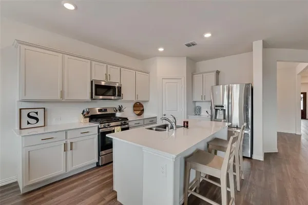 a kitchen with a sink a stove a refrigerator cabinets and a center island