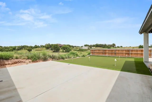 a view of swimming pool with a yard and large trees