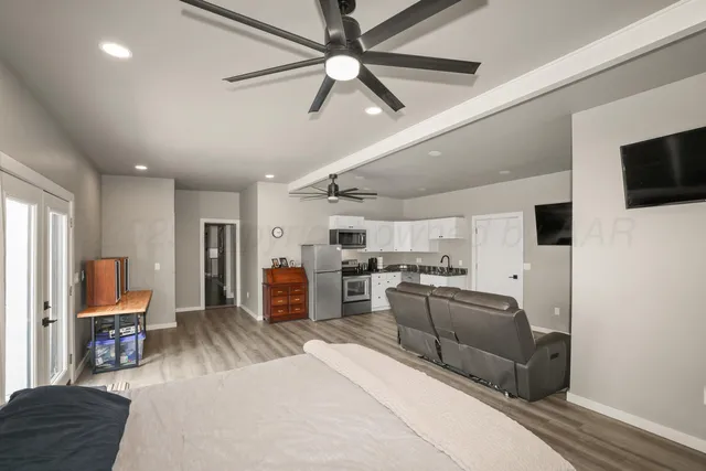 a room with stainless steel appliances furniture and a flat screen tv