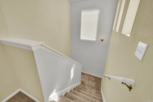 an empty room with windows and chandelier fan
