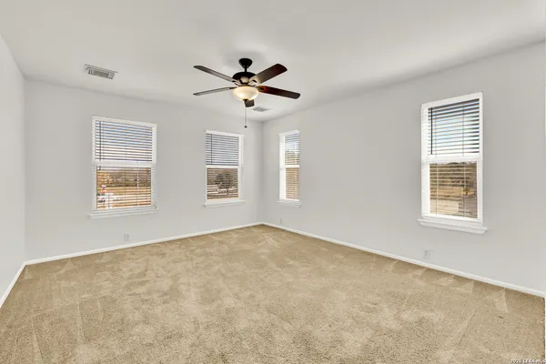 a spacious bedroom with a bed a couch and dresser