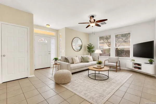a living room with furniture a flat screen tv and a window