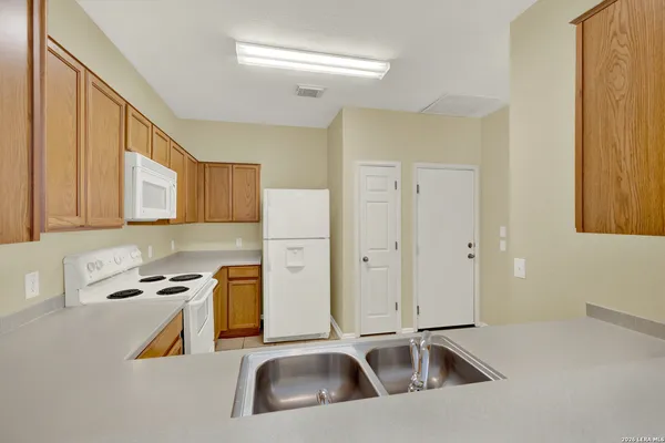 a kitchen with stainless steel appliances a sink a stove and a refrigerator with wooden floor