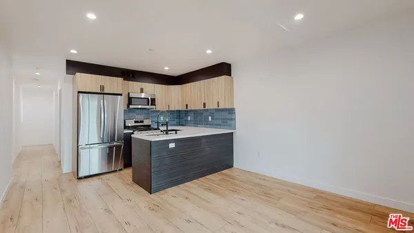 a kitchen with stainless steel appliances granite countertop a refrigerator and a stove top oven