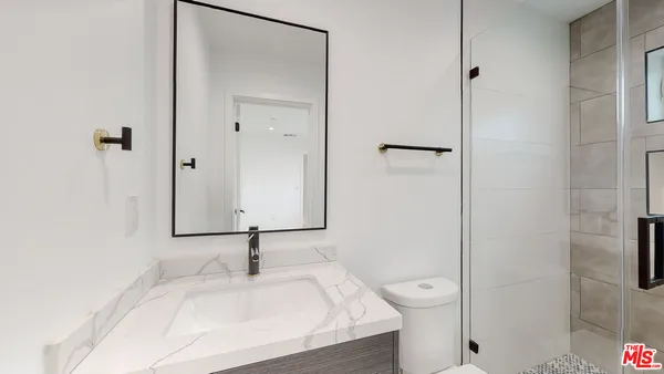 a bathroom with a sink a toilet and a mirror