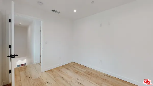 a view of a room with wooden floor and a bathroom