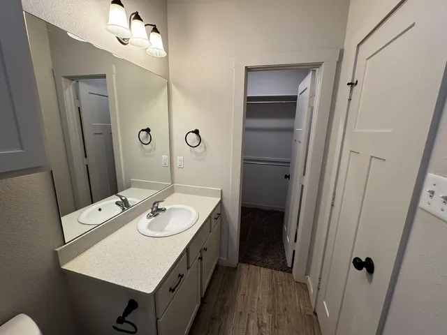 a bathroom with a granite countertop sink a mirror and shower